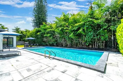 a swimming pool in a backyard with trees at Villa Aura Heated Pool 4 Bedrooms 5 minutes to the Ocean in Fort Lauderdale