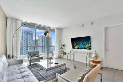 a living room with white furniture and a large window at Water front Icon Brickell, W Hotel building in Miami