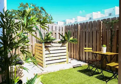 a backyard with a wooden fence and a table and chairs at Insta Worthy Oasis in Homestead