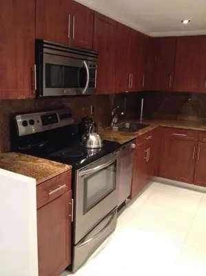 a kitchen with a stove and a microwave at Apartamento en Miami Beach sobre la playa in Miami Beach