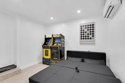 a bedroom with a black bed in a white room at Spacious 5 Bedrooms with Large Pool, 12 minutes to the Ocean in Fort Lauderdale