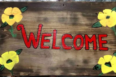 a welcome sign with yellow flowers on a wooden surface at NEW Luxurious Studio Private in the heart of Miami in Miami