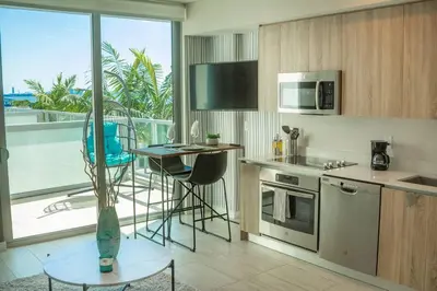 a kitchen with a table and a view of a balcony at Luxury Oceanview Studio at Miami Design District in Miami