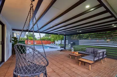a porch with a swing and a couch at Top Location Villa at Highland Lakes Blvd BY THE GLAMHOMES in Miami