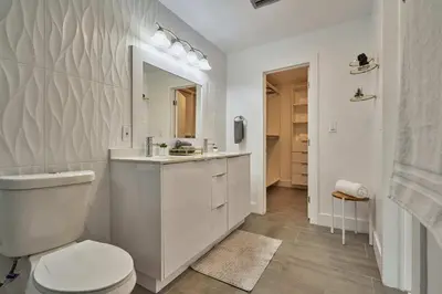 a white bathroom with a toilet and a sink at Top Location Villa at Highland Lakes Blvd BY THE GLAMHOMES in Miami