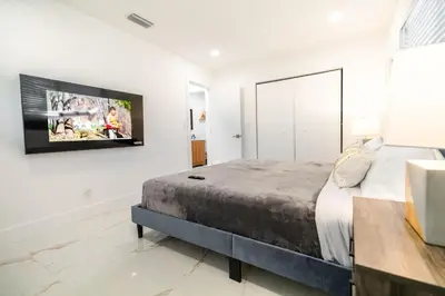 a bedroom with a bed and a tv on the wall at Amazing Villa at Highland Lakes Boulevard BY THE GLAMHOMES in Miami