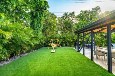 a playground in the backyard of a house with green grass at Amazing Villa at Highland Lakes Boulevard BY THE GLAMHOMES in Miami