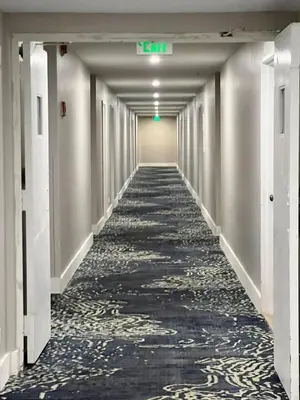 an empty hallway with ailed floor and a green exit sign at Entire Beach Front Condo w/ pool Amazing view 4pax in Miami Beach