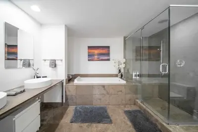 a bathroom with a shower and a tub and a sink at Luxury Ocean View 2BR Corner Unit at W residence in Miami