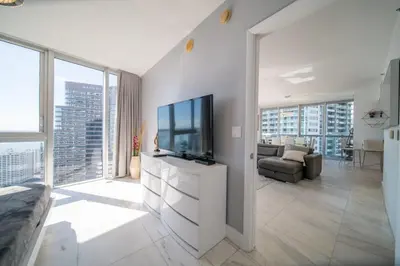 a living room with a television and a couch at Luxury Ocean View 2BR Corner Unit at W residence in Miami