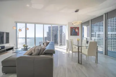a living room with a couch and a table with chairs at Luxury Ocean View 2BR Corner Unit at W residence in Miami