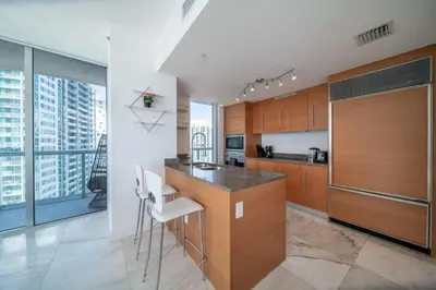 a kitchen with wooden cabinets and a counter top at Luxury Ocean View 2BR Corner Unit at W residence in Miami