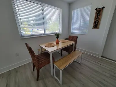 a dining room with a table and chairs and windows at Sol Miami #1 with free parking on premises in Miami