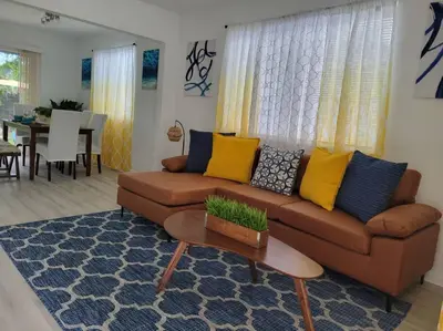 a living room with a brown couch with yellow and blue pillows at Sol Miami # 2 with free parking in Miami