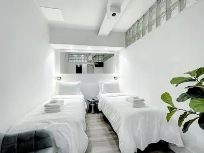 two beds in a room with white sheets at Oceanfront 3 Room Ocean Drive Condo in Miami Beach