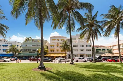 a park with palm trees in front of buildings at Oceanfront 3 Room Ocean Drive Condo in Miami Beach