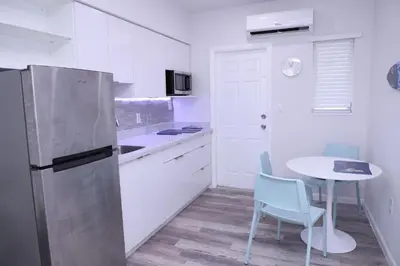 a kitchen with a refrigerator and a table and chairs at Douglas rd apartments in Miami