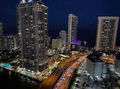 a city skyline with tall buildings and a street at night at Trendy Beachfront Flat, Sea Views, Style & Amenities -A in Hallandale Beach