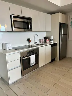 a kitchen with a stainless steel stove and refrigerator at Trendy Beachfront Flat, Sea Views, Style & Amenities -A in Hallandale Beach
