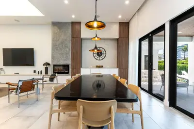 a dining room with a black table and chairs at Super Modern Waterfront Paradise Near the Beach in Miami