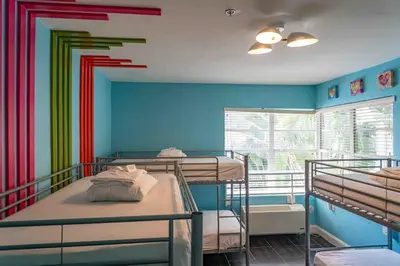a room with three bunk beds and a window at Beds n' Drinks in Miami Beach
