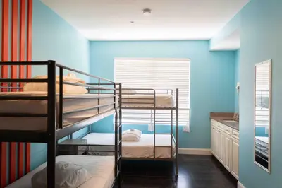 a bunk room with three bunk beds and a blue wall at Beds n' Drinks in Miami Beach