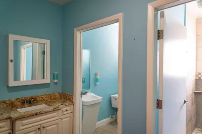 a bathroom with a toilet and a sink and a mirror at Beds n' Drinks in Miami Beach