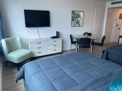 a bedroom with a bed and a table and a tv at Studio Miami Beach sobre la playa in Miami Beach