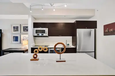 a kitchen with a white counter top with a wooden chair at Villa Vista-2 Story w 3Bdrms & Golf View in Miami