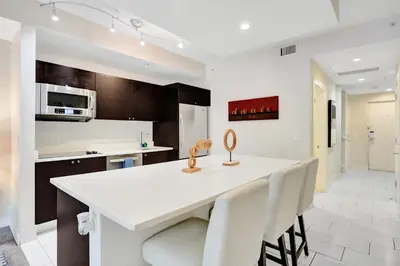 a kitchen with a white counter and white chairs at Villa Vista-2 Story w 3Bdrms & Golf View in Miami