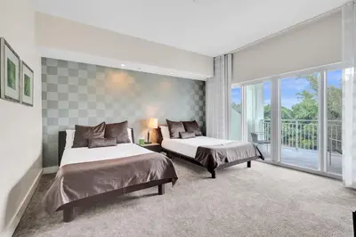 a bedroom with two beds and a balcony at Villa Vista-2 Story w 3Bdrms & Golf View in Miami