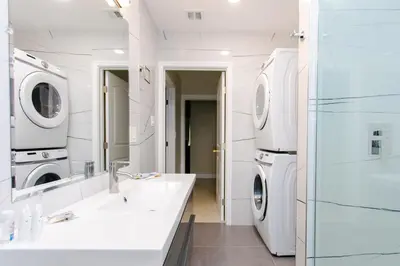 a white bathroom with a sink and a washer and dryer at First-Class 5BR Villa in Hollywood Lakes in Hollywood