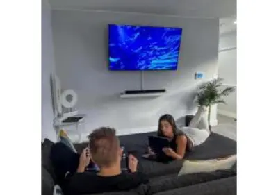 a man and a woman sitting on a couch with a laptop at Massage Chair - Backyard - 5 min 2 DT Calle 8 Brickell in Miami