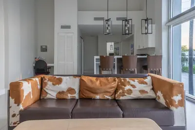 a living room with a brown couch with brown and white pillows at The Biscayne Hotel in Miami