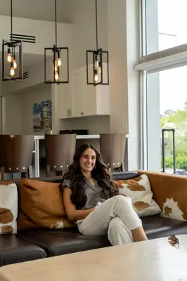 a woman sitting on a couch in a living room at The Biscayne Hotel in Miami