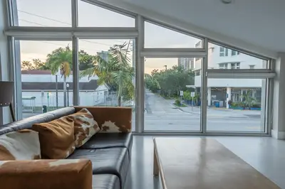 a living room with a couch and large windows at The Biscayne Hotel in Miami