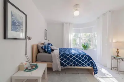 a white bedroom with a bed and a window at BEACH VIBES in Miami Beach