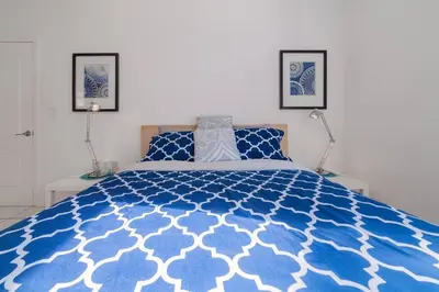 a blue and white bed in a bedroom with two lamps at BEACH VIBES in Miami Beach