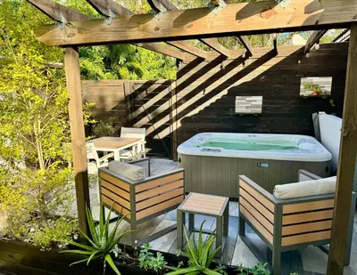 a hot tub sitting under a wooden pergola at HOT TUB HOUSE ON GOLF COURSE! 10 MINs TO THE BEACH in Miami