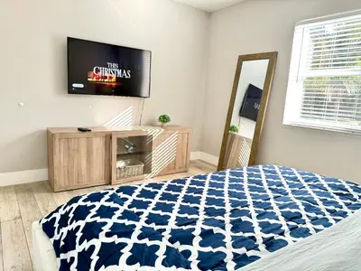 a bedroom with a bed and a flat screen tv at HOT TUB HOUSE ON GOLF COURSE! 10 MINs TO THE BEACH in Miami