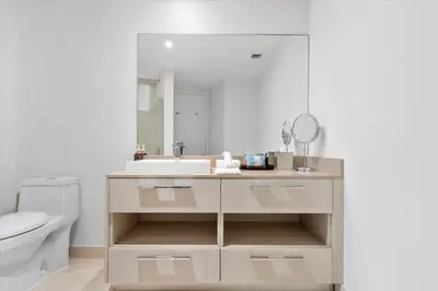 a bathroom with a sink and a toilet and a mirror at Stay on the beach-16th Floor Views Pool Gym in Hallandale Beach