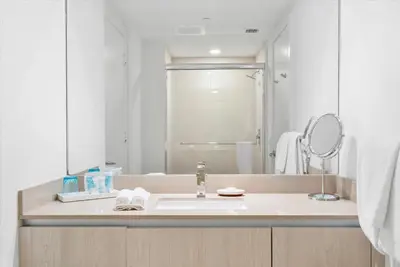 a white bathroom with a sink and a mirror at Stay on the beach-16th Floor Views Pool Gym in Hallandale Beach