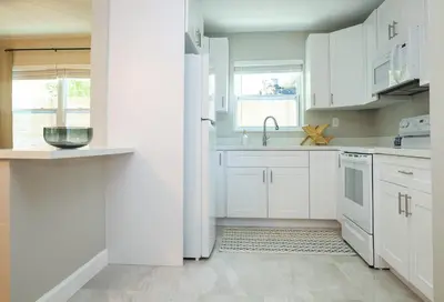 a white kitchen with white cabinets and a sink at La Vie Boheme 2 - Charming Oasis w Parking in Miami