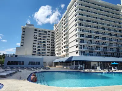a large apartment building with a large swimming pool at Estudios para 4 personas en la playa de Sunny Isles Beach in Miami Beach