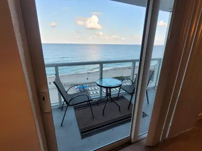 a balcony with a table and chairs and the ocean at Estudios para 4 personas en la playa de Sunny Isles Beach in Miami Beach