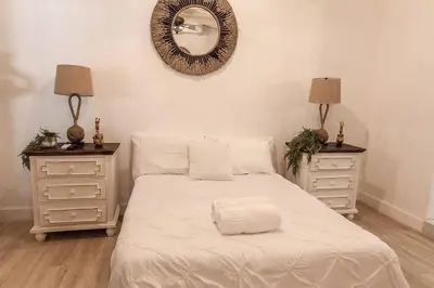 a bedroom with a bed with two dressers and a mirror at Luxury Miami Village w/Pool+Grill+MiniGolf in Miami