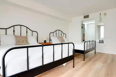a bedroom with two beds and a wooden floor at One of Brickell Bays Best with Pool and Gym Access in Miami