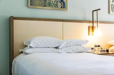a bed with white sheets and pillows in a room at Lovely Deluxe Unit Located at Ritz Carlton - Key Biscayne! in Miami