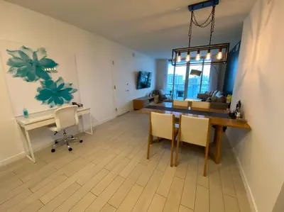 a living room with a table and chairs and a desk at Refined Oceanview Apartment, Kitchen, Comfort & Location -A in Hallandale Beach