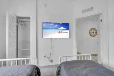 a bedroom with two beds and a tv on the wall at Subtle 2 Bed in Edgewater near Downtown With Free Parking in Miami